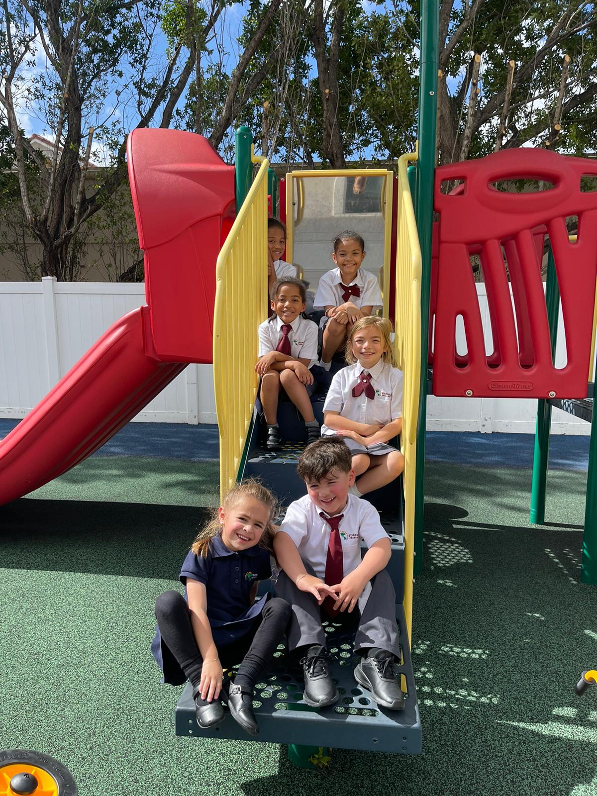 Kids sitting in the STARS Global Prep playground during recess